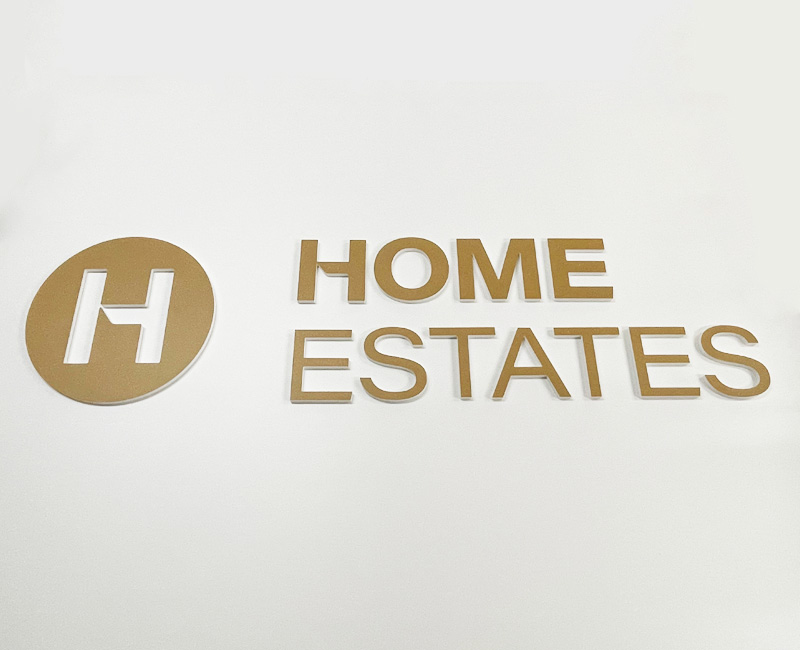 Logo przestrzenne na ścianę złote Home Estates od Studio EFEKT